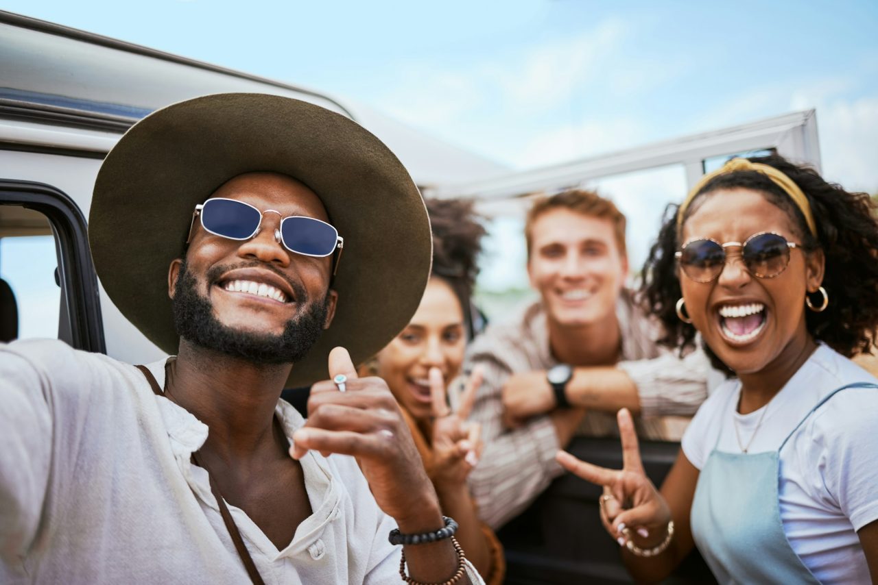 travel-adventure-and-selfie-with-friends-celebrating-freedom-and-showing-hand-peace-sign-outdoors-.jpg